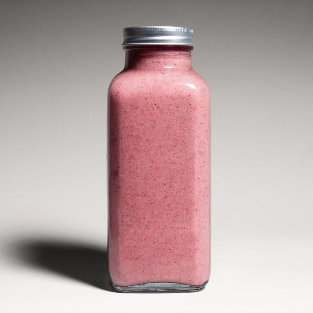 Dragon Fruit Smoothie – Vibrant pink dragon fruit smoothie in a reusable to-go bottle, set against a clean studio backdrop with soft lighting.