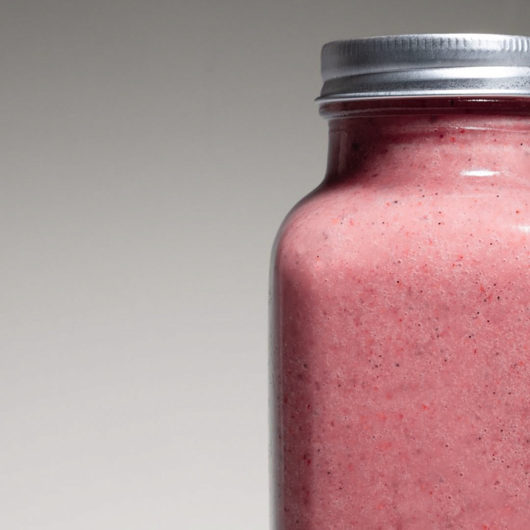 Dragon Fruit Smoothie – Vibrant pink dragon fruit smoothie in a reusable to-go bottle, set against a clean studio backdrop with soft lighting.