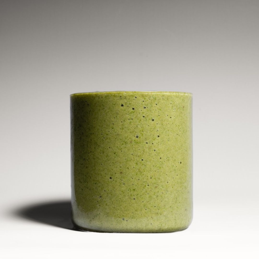 A fresh green Nature’s Balance smoothie served in a modern, minimalistic glass, styled in a studio setting with a fresh and contemporary backdrop.